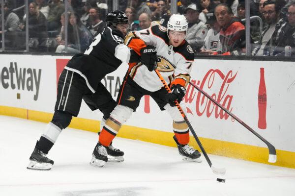 Anaheim Ducks right wing Frank Vatrano (77) passes while defended by Los Angeles Kings defenseman Jordan Spence (53) during the first period of an NHL hockey game Tuesday, Dec. 20, 2022, in Los Angeles. (AP Photo/Ashley Landis)