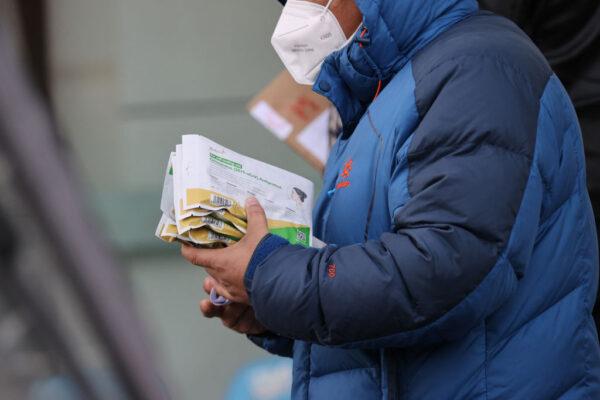 A man holds antigen test kits as he leaves a pharmacy amid the Covid-19 pandemic in Xian, in China's northern Shaanxi province on Dec. 20, 2022. (STR/AFP via Getty Images)