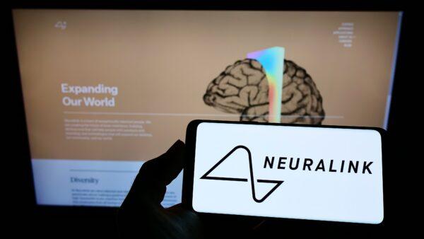 Neuralink company logo on a phone and its website on a computer. (Shutterstock)