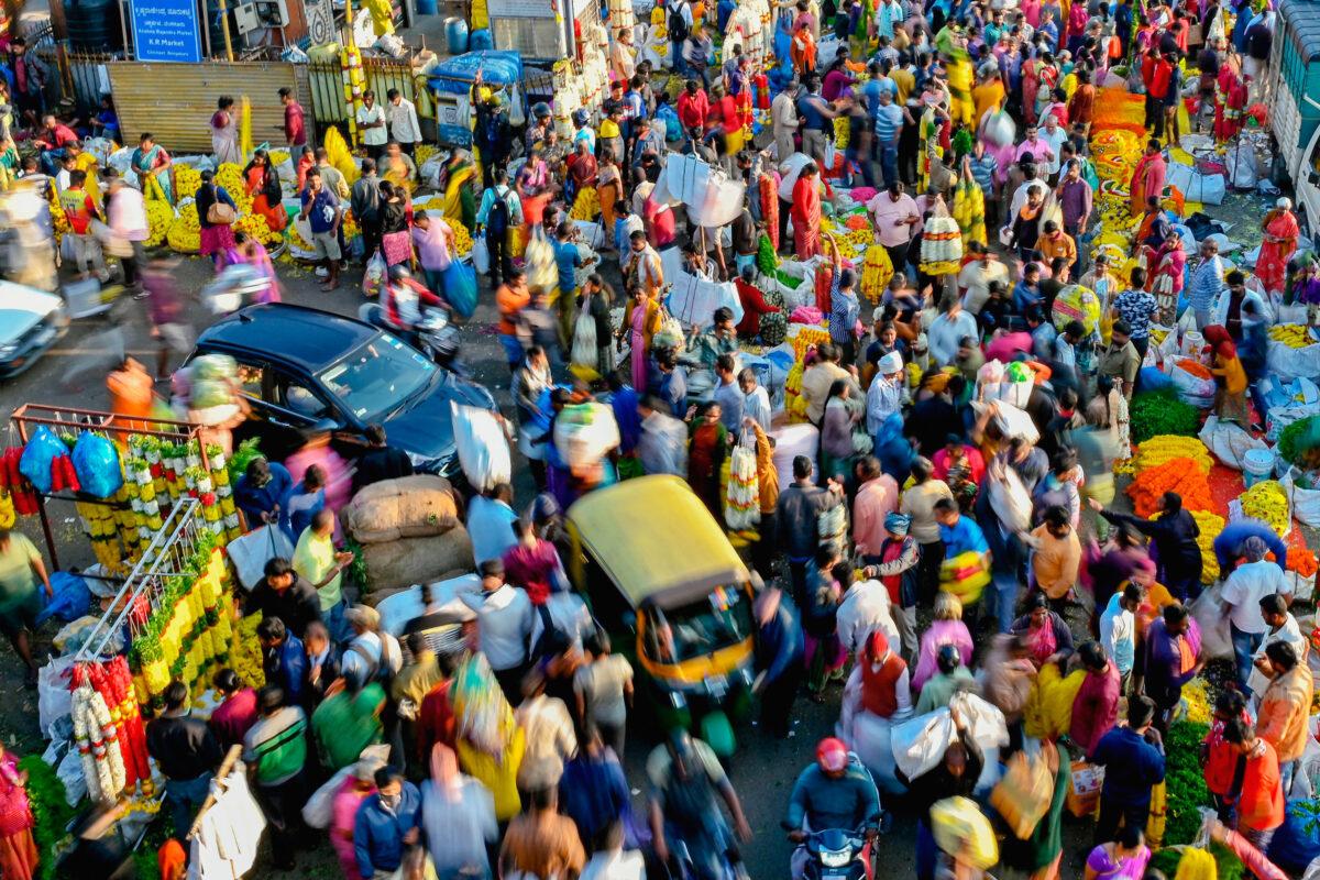 People walk through a market in Bangalore, India, on Nov. 15, 2022. The global population has topped the symbolic milestone of 8 billion people, according to a United Nations estimate. (MANJUNATH KIRAN/AFP via Getty Images)