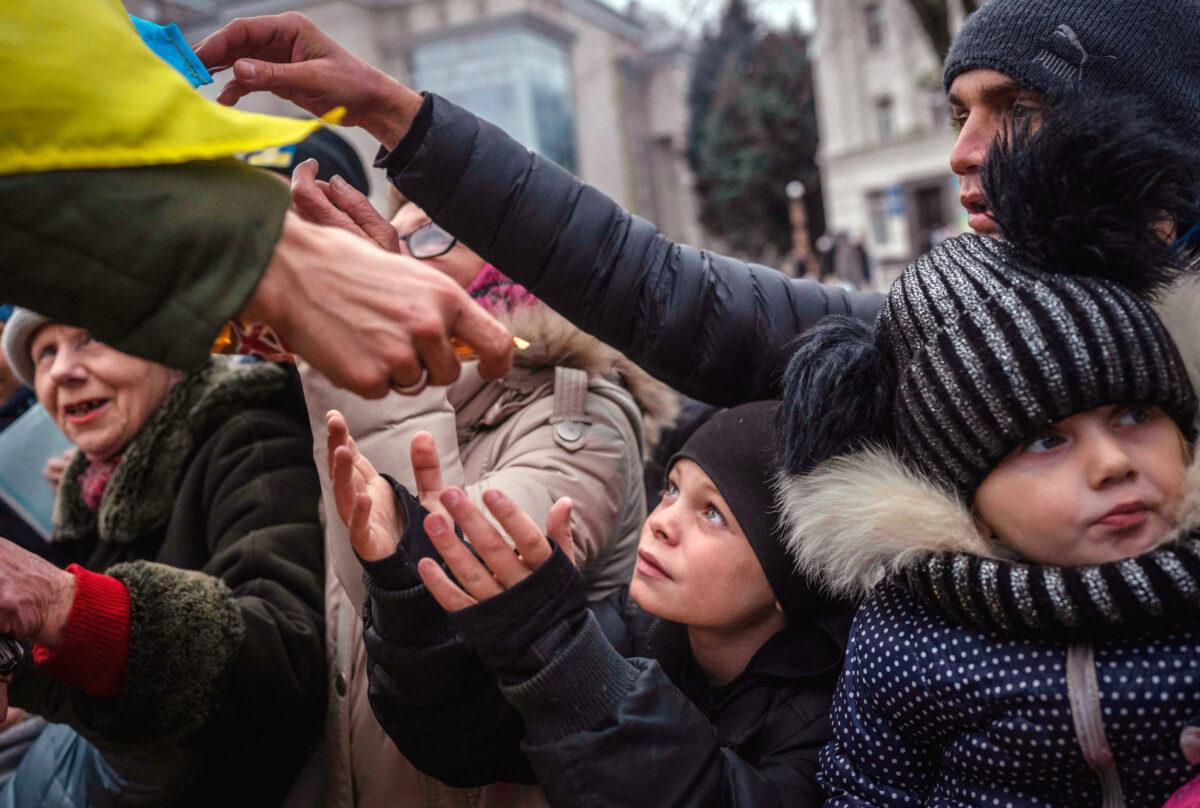 A child receives aid in Kherson, Ukraine, on Nov. 18, 2022, after almost half of the country's energy infrastructure was disabled by Russian strikes, leaving about 10 million Ukrainians without power. (BULENT KILIC/AFP via Getty Images)