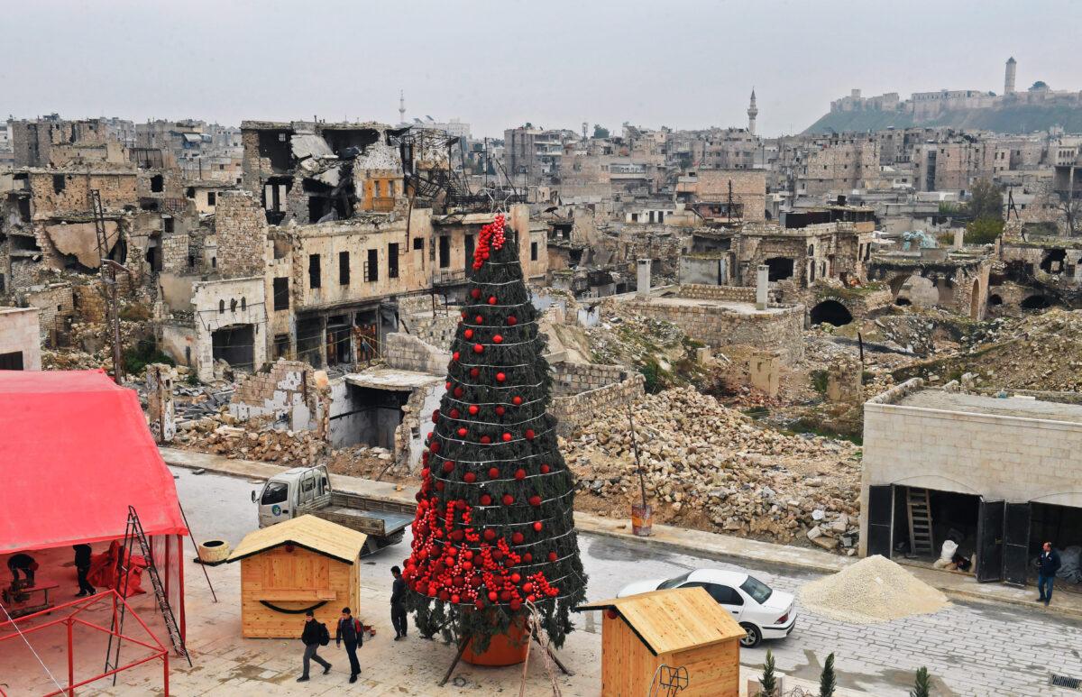 Workers set up a Christmas tree in Al-Hatab Square, one of Syria’s oldest squares, in the northern city of Aleppo on Dec. 12, 2022. (AFP via Getty Images)