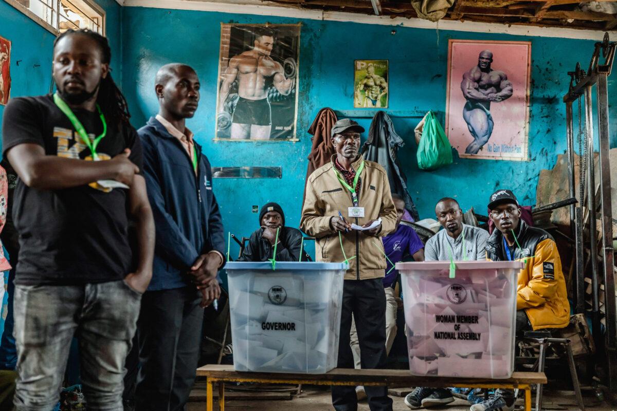 Kenyan Electoral Commission officials observe voters casting ballots during the general election at a polling station in the Mathare Social Hall in Nairobi no Aug. 9, 2022. (LUIS TATO/AFP via Getty Images)