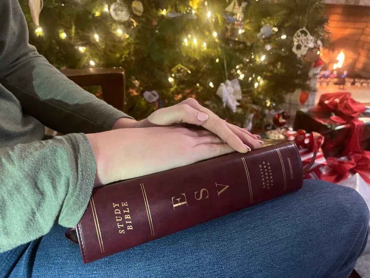 A Florida university student, who asked to be identified only as Mia, sits with her Bible at home on Christmas break on Dec. 22, 2022. Expressing Christian views on campus draws scorn from professors, who openly talk about their "hate" for Christians, she told The Epoch Times. (Courtesy of Mia)