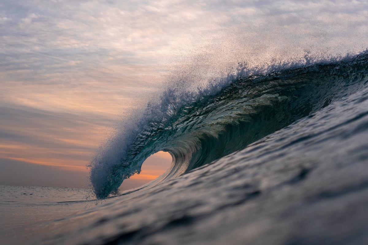 A wave about to crash before an orange-tinged morning backdrop. (Courtesy of <a href="https://www.instagram.com/orangerocks.za/">Terence Pieters</a>)