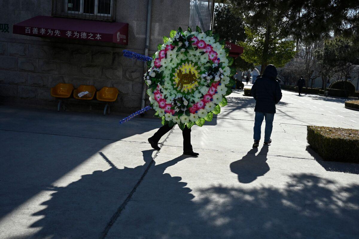 A man holds a wreath of flowers at a crematorium in Beijing on Dec. 22, 2022. (STF/AFP via Getty Images)