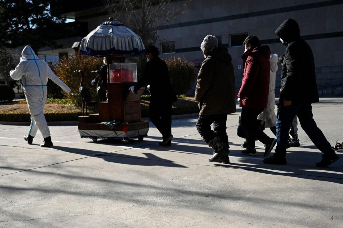 Family members follow an urn containing the ashes of a loved one at a crematorium in Beijing on Dec. 22, 2022. (STF/AFP via Getty Images)