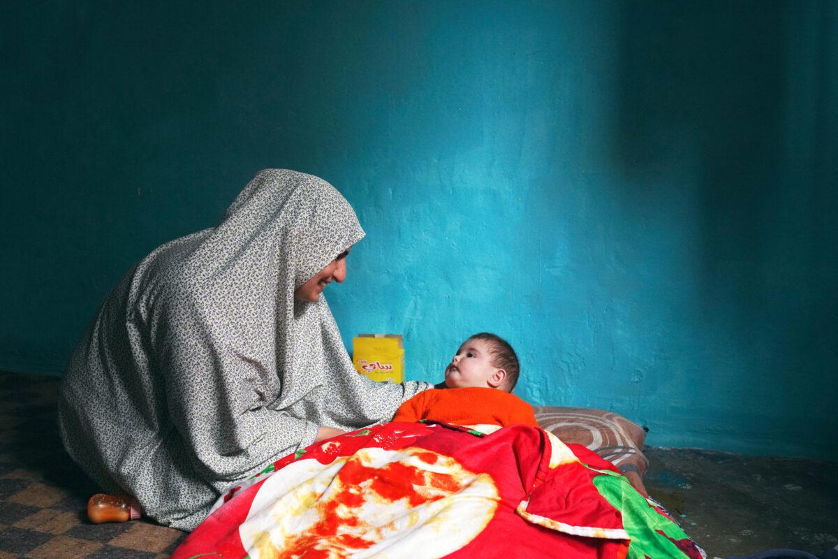 Mariam Ahmad, a Syrian refugee from Aleppo, smiles as she looks at her child in her home in Tripoli, Lebanon, on Jan. 5, 2022. (Andreea Campeanu/Getty Images)