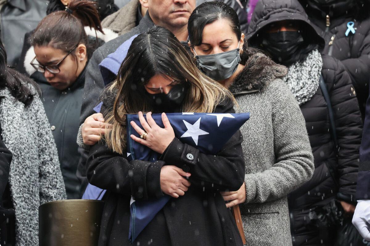 Dominique Rivera, wife of fallen New York Police Department Officer Jason Rivera, hugs the flag from his casket during his funeral at St. Patrick's Cathedral in New York, on Jan. 28, 2022. (Spencer Platt/Getty Images)