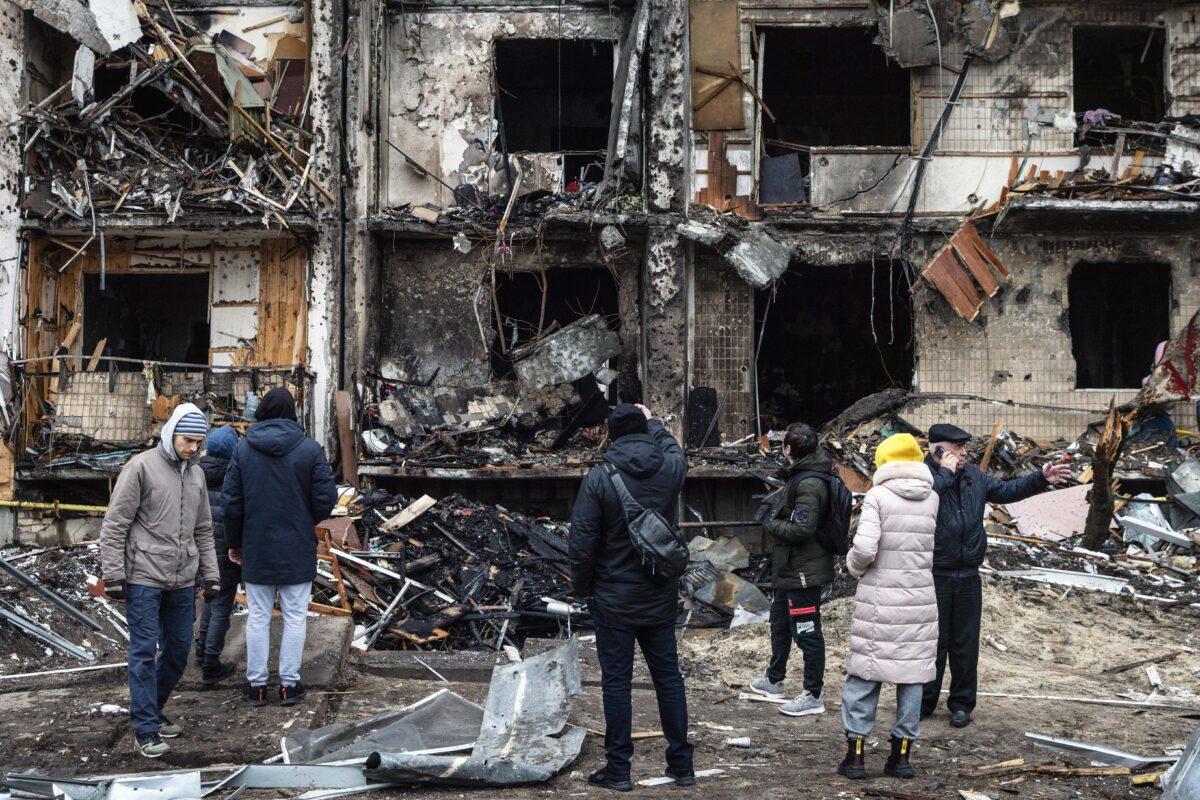 People look at the exterior of a damaged residential block hit by an early morning missile strike in Kyiv, Ukraine, on Feb. 25, 2022, the day after Russia launched a large-scale attack on the nation. (Chris McGrath/Getty Images)
