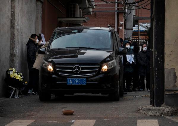 People gather around a hearse carrying the body of a loved one from an area outside a hospital fever clinic in Beijing, China, on Dec. 21, 2022. (Kevin Frayer/Getty Images)
