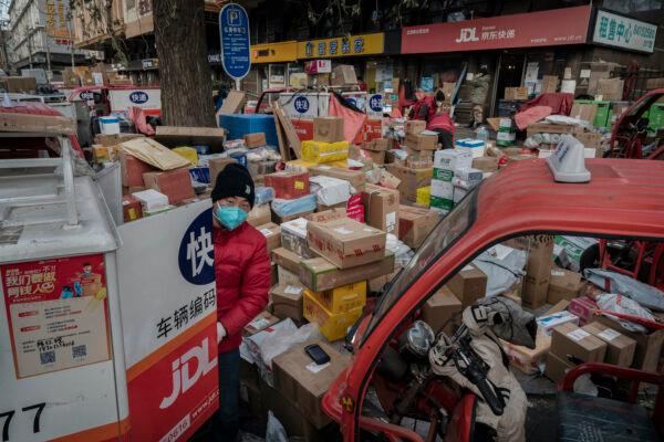 A delivery driver organizes packages in the street that are part of a backlog due to COVID-19 outbreaks outside a depot on Dec. 21, 2022, in Beijing, China. (Kevin Frayer/Getty Images)