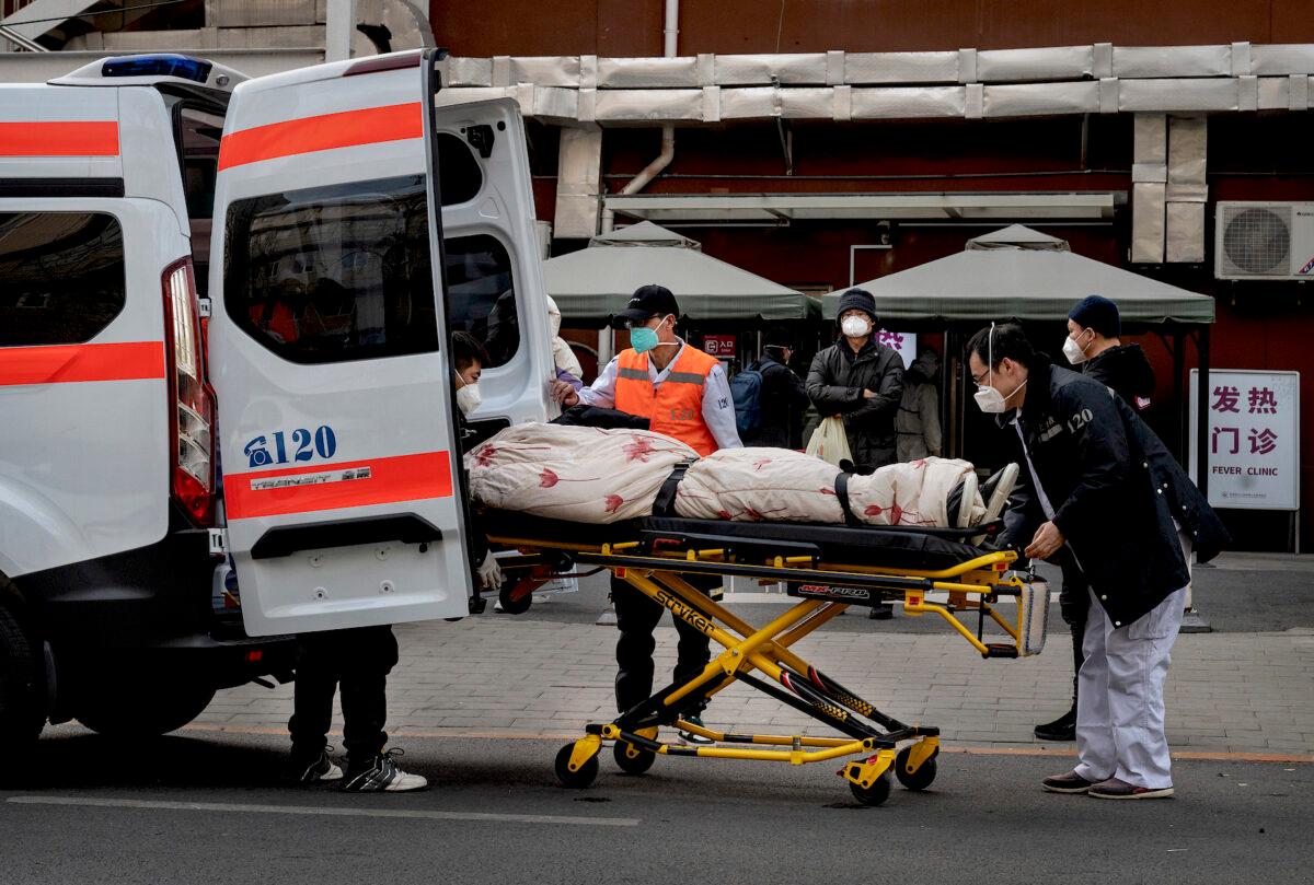 Ambulance drivers unload a patient outside a clinic treating COVID-19 patients in Beijing on Dec. 21, 2022. (Kevin Frayer/Getty Images)