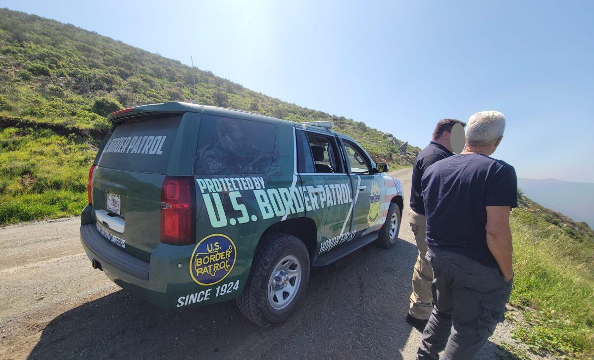 Two men talk next to a border patrol vehicle. (Courtesy of Morale Boosters)