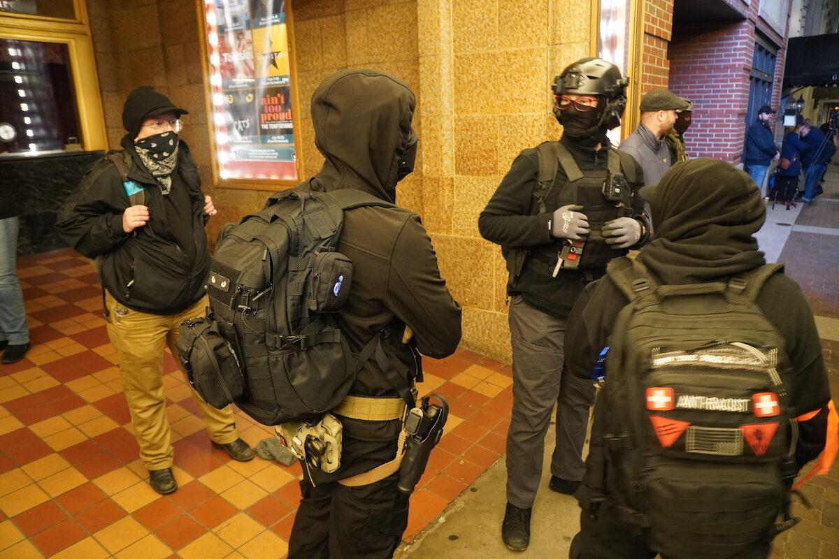 Armed Antifa members with orange ribbons prepare to intimidate the press at a drag show accessible to children on the street outside the Tennessee Theatre in Knoxville, Tenn., on Dec. 22, 2022. (Jackson Elliott/The Epoch Times)