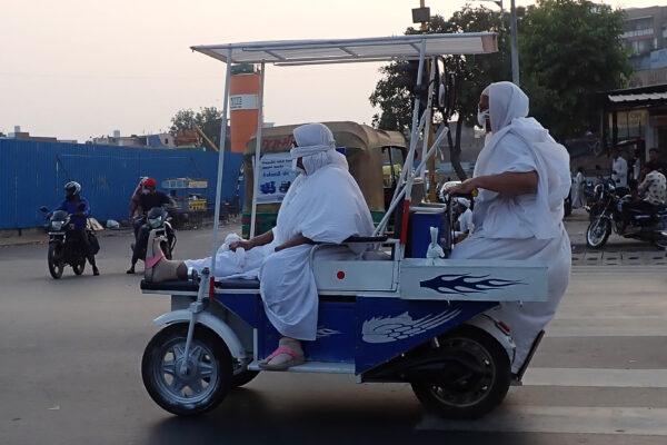 Jain monks ride on an electric vehicle along a street in Ahmedabad, India, on Nov. 20, 2021. (Sam Panthaky/AFP via Getty Images)