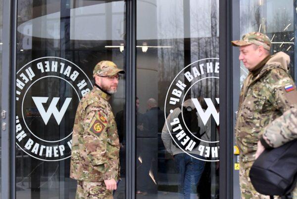 Visitors wearing military camouflage stand at the entrance of the "PMC Wagner Centre" during the official opening of the office block on National Unity Day, in St. Petersburg, on Nov. 4, 2022. (Olga Maltseva/AFP via Getty Images)