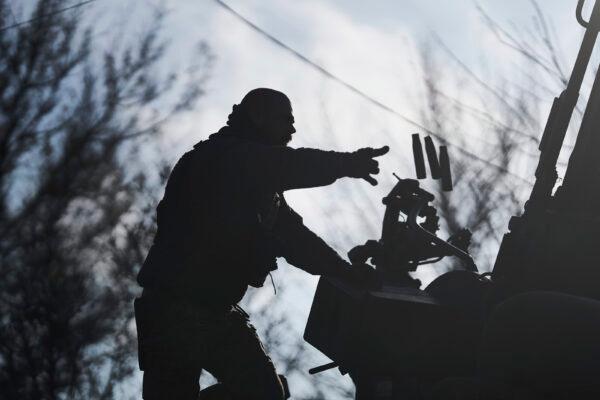 A Ukrainian soldier throws bullet casings from an armored vehicle near Bakhmut, Donetsk region, Ukraine, on Dec. 22, 2022. (Libkos/AP Photo)