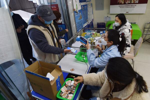 A man buys fever medicine at a pharmacy amid the COVID-19 pandemic in Nanjing, in China's eastern Jiangsu Province, on Dec. 19, 2022, as the pharmacy offers six capsules for each client. (STR/AFP via Getty Images)