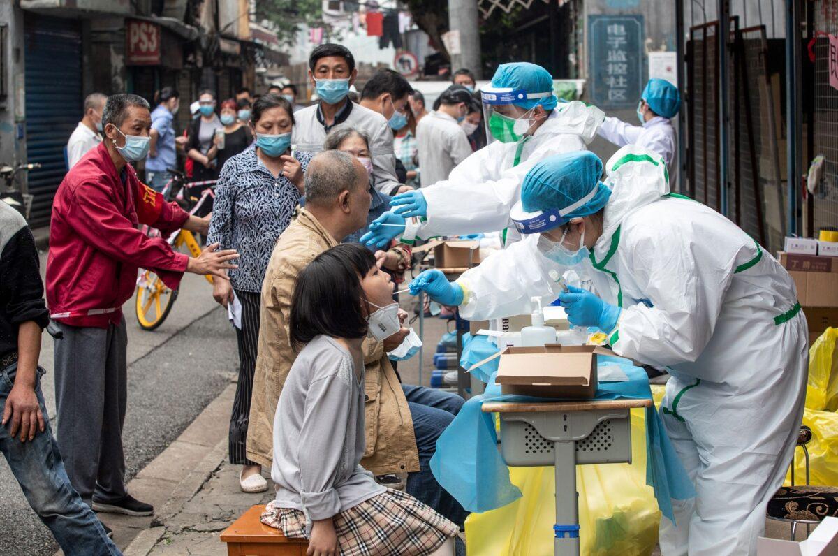 Medical workers take swab samples from residents to be tested for COVID-19 in a street in Wuhan, Hubei Province, China, on May 15, 2020. (STR/AFP via Getty Images)