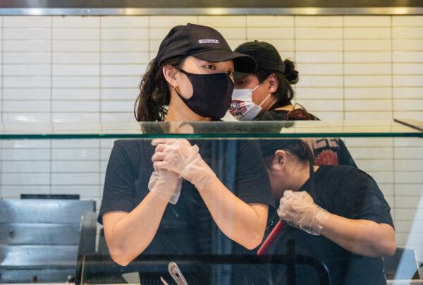 Staff working at a Chipotle Mexican Grill in Houston, Texas, on June 9, 2021. Menu prices at Chipotle Mexican Grill rose during this time by roughly four percent to cover the costs of raising its minimum wage to $15 an hour for employees. (Brandon Bell/Getty Images)