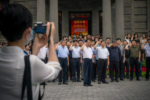 Visitors take an oath in front of a communist flag (not seen) at the entrance of Peking University's Red Building, where a new exhibition has then set up as part of the 100th anniversary of the Communist Party of China, on June 30, 2021. (Andrea Verdelli/Getty Images)