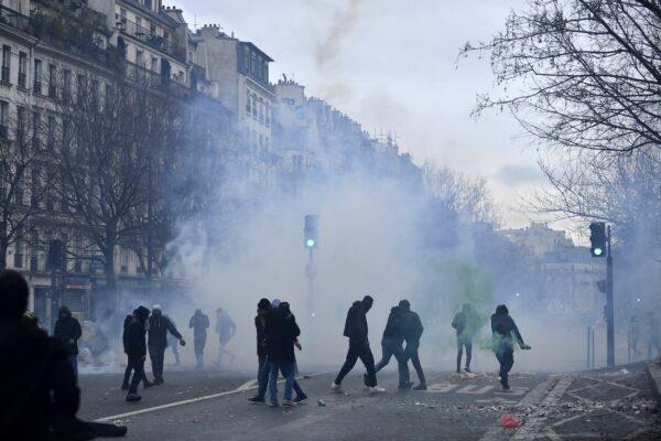 Protesters stand amid tear gas smoke during clashes following a demonstration of supporters and members of the Kurdish community, a day after a gunman opened fire at a Kurdish cultural center killing three people, at The Place de la Republique in Paris on Dec. 24, 2022. (Julien de Rosa/AFP via Getty Images)