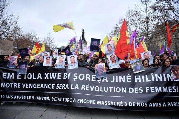 Protesters hold Kurdish workers party (PKK) flags and portraits of victims during a demonstration of supporters and members of the Kurdish community, a day after a gunman opened fire at a Kurdish cultural center killing three people, at The Place de la Republique in Paris on Dec. 24, 2022. (Julien de Rosa/AFP via Getty Images)