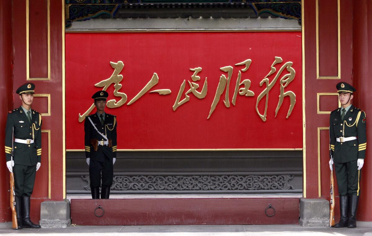 Chinese paramilitary guards stand in front of a slogan reading "Serve the People" displayed at the Zhongnanhai communist leaders compound in Beijing, on Oct. 7, 2007. (The Eng Koon/AFP via Getty Images)