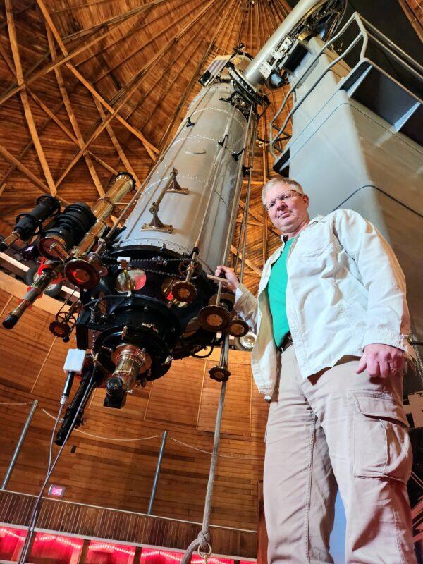 Lowell Observatory historian Kevin Schindler stands beside the 24-inch refractor telescope in Flagstaff, Ariz., on Dec. 20, 2022. The late astronomer Percival Lowell had the observatory built in order to confirm the existence of canals on Mars. (Allan Stein/The Epoch Times)