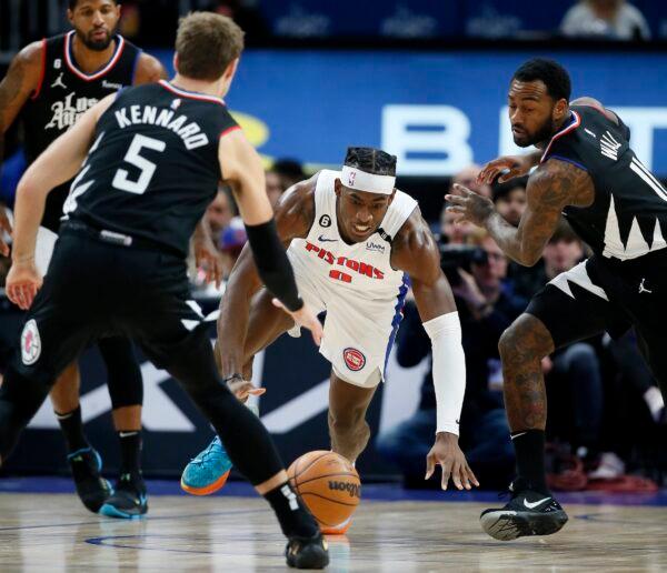 Detroit Pistons center Jalen Duren (0) chases a loose ball against Los Angeles Clippers guards Luke Kennard (5) and John Wall (11) during the first half of an NBA basketball game in Detroit on Dec. 26, 2022. (Duane Burleson/AP Photo)