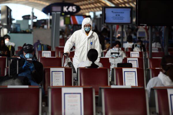 Passengers wearing protective clothing wait before boarding a China Southern Airlines to Guangzhou at Paris Charles de Gaulle Airport on May 12, 2020. (Eric Piermont/AFP via Getty Images)