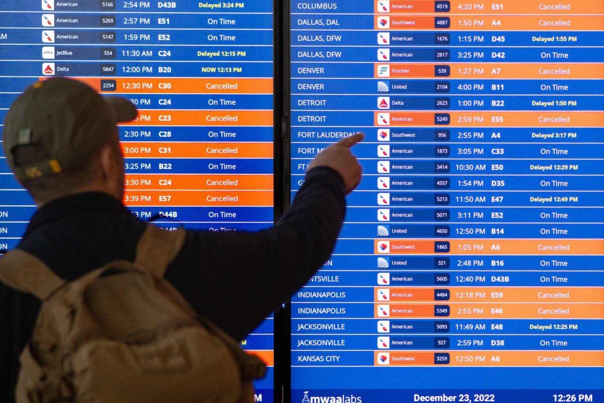 A traveler looks at an information board showing flight cancellations and delays at Ronald Reagan Washington National Airport during a winter storm ahead of the Christmas holiday in Arlington, Va., on Dec. 23, 2022. (Mandel Ngan/AFP via Getty Images)