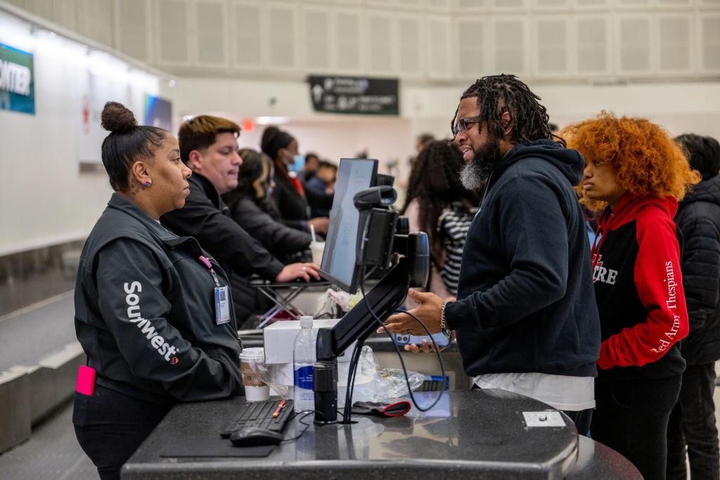 Derrick Vinson speaks with a Southwest Airlines associate about his son being stranded due to canceled and delayed flights at George Bush Intercontinental Airport in Houston, Texas, on Dec. 27, 2022. (Brandon Bell/Getty Images)