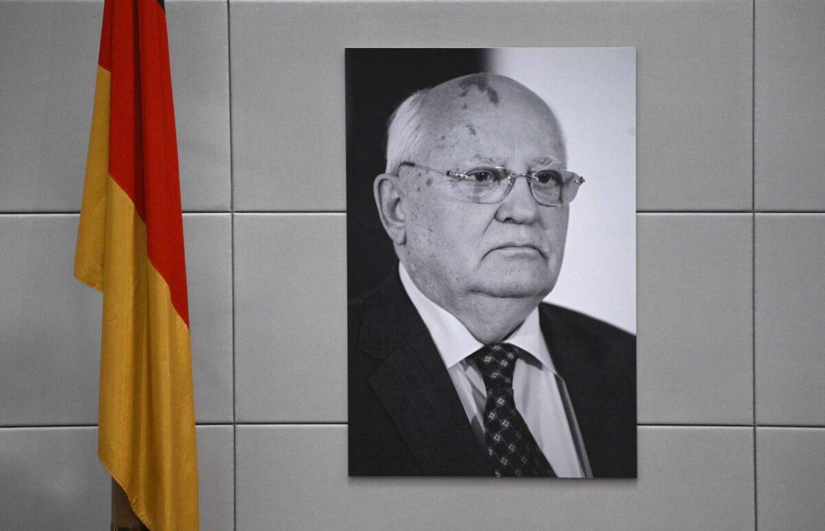 A portrait of Mikhail Gorbachev, the last leader of the Soviet Union, hangs next to a German flag prior to a session of the Bundestag, the lower house of parliament, in Berlin, Germany, on Sept. 7, 2022. (Tobias Schwarz/AFP/Getty Images)