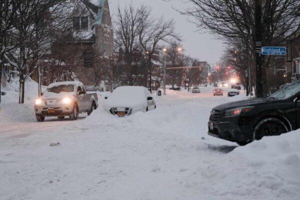 Vehicles make their way along a snow-covered street in Buffalo, N.Y., on Dec. 26, 2022. (Joed Viera/AFP via Getty Images)