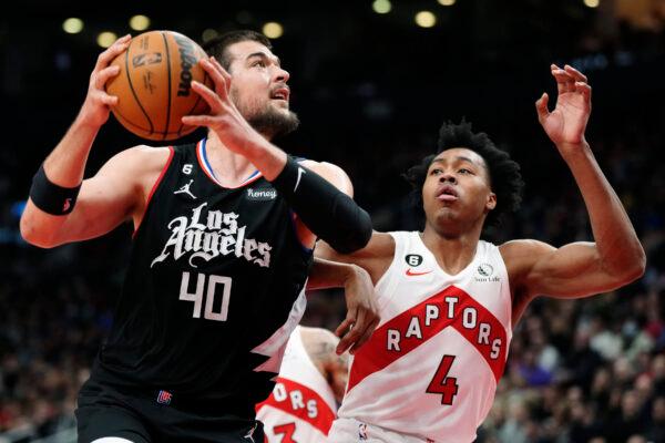 Los Angeles Clippers center Ivica Zubac (40) drives as Toronto Raptors forward Scottie Barnes (4) defends during the first half of an NBA basketball game in Toronto on Dec. 27, 2022. (Frank Gunn/The Canadian Press via AP)