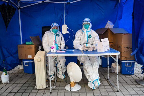 Health workers wait for people to scan a health code to test for the COVID-19 coronavirus in the Jing'an district in Shanghai, China, on Dec. 22, 2022. (Hector Retamal/AFP via Getty Images)