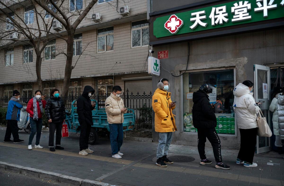 People wait in line to buy medicine at a pharmacy in Beijing, China, on Dec. 9, 2022. (Kevin Frayer/Getty Images)