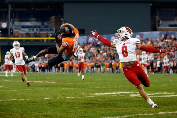 Wide receiver Brennan Presley (80) of the Oklahoma State Cowboys catches a pass over cornerback Avyonne Jones (8) of the Wisconsin Badgers during the second half of the Guaranteed Rate Bowl at Chase Field in Phoenix on Dec. 27, 2022. (Chris Coduto/Getty Images)