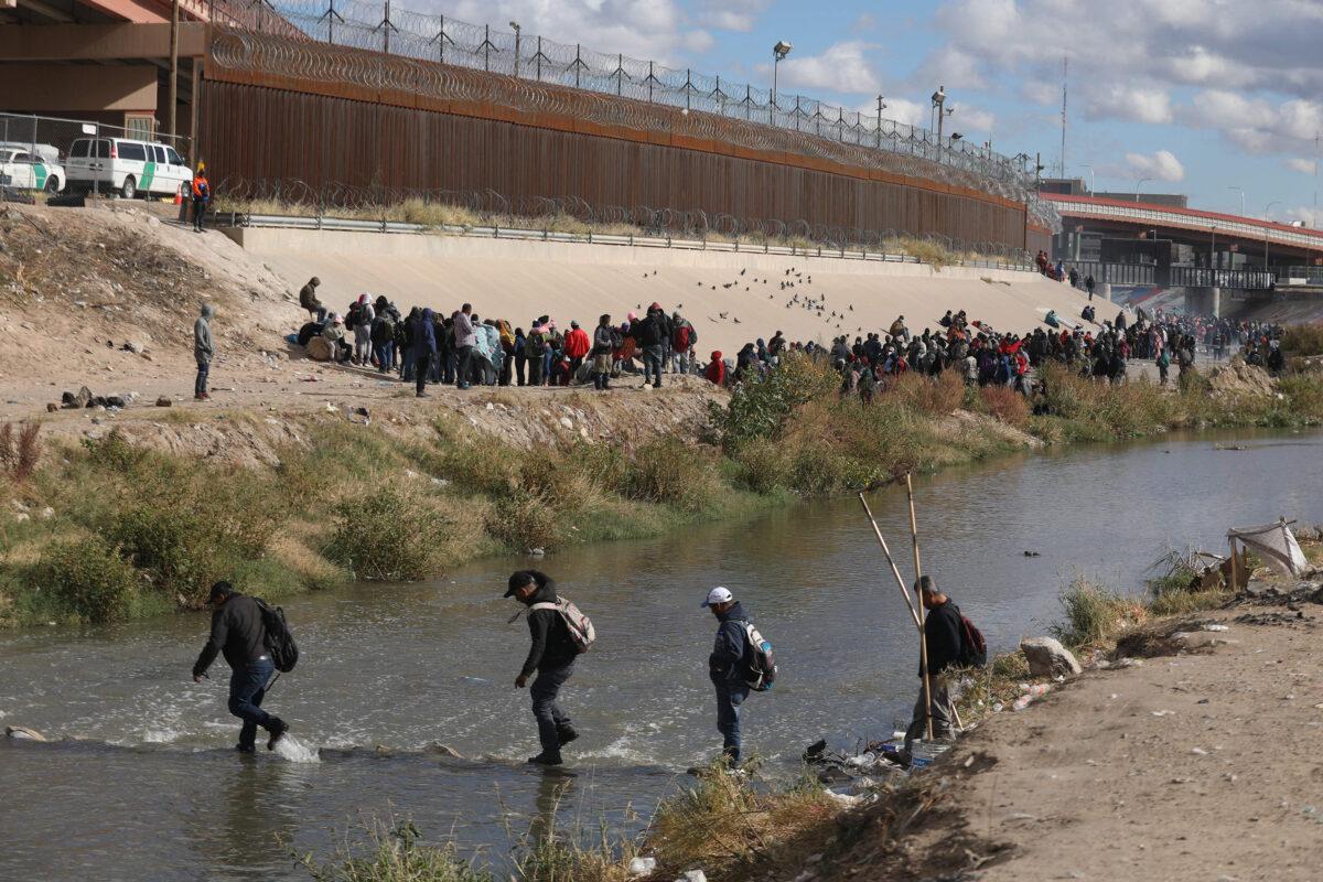 People walk across the Rio Grande to surrender to U.S. Border Patrol agents in El Paso, Texas, as seen from Ciudad Juárez, Mexico, on Dec. 13, 2022. (Herika Martinez/AFP/Getty Images)