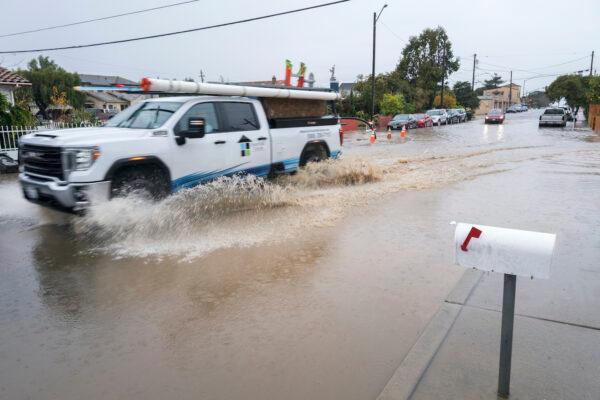 A truck drives through a flooded intersection of E Bolivar Street in Salinas, Calif., on Dec. 27, 2022. (Nic Coury/AP Photo)
