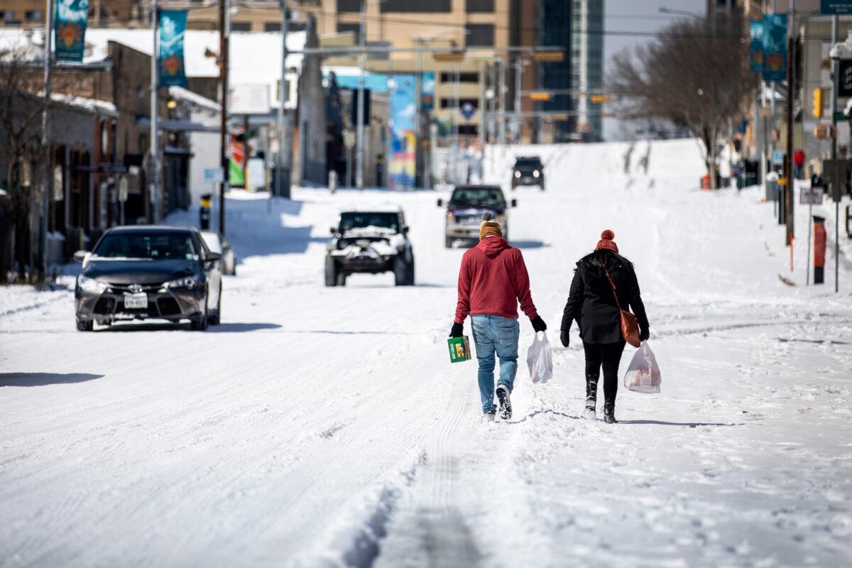 People carry groceries from a local gas station in Austin, Texas, on Feb. 15, 2021. Winter Storm Uri brought historic cold weather to Texas, causing traffic delays and power outages. (Montinique Monroe/Getty Images)