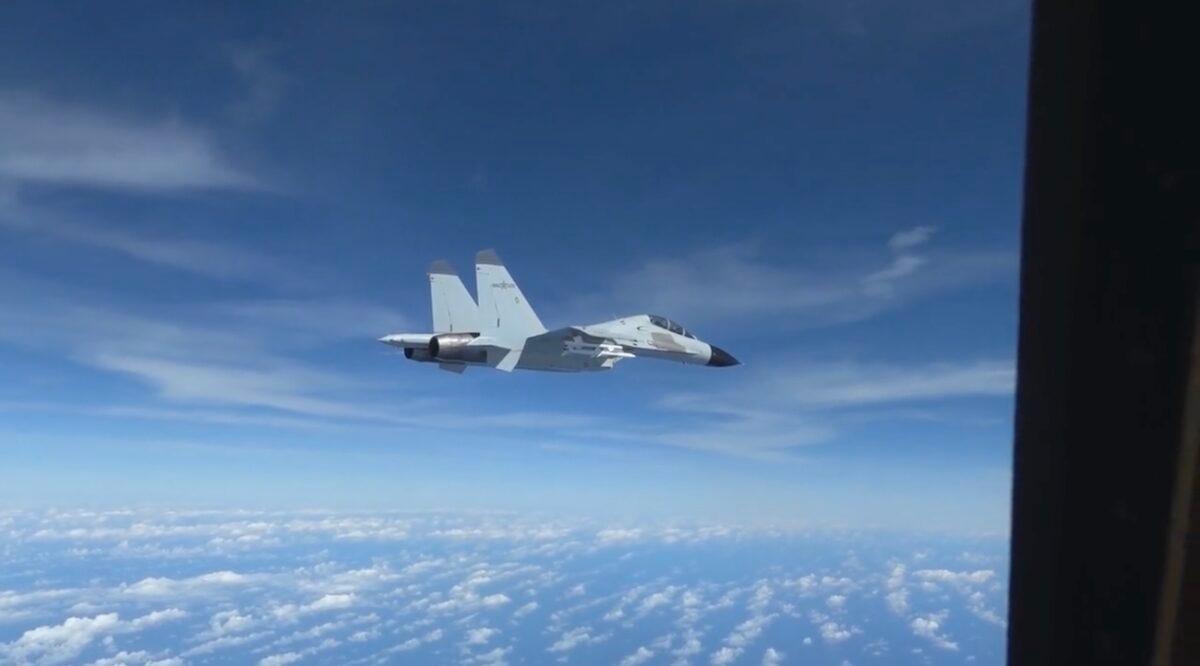 A People’s Liberation Army Navy J-11 fighter pilot performs an unsafe maneuver during an intercept of a U.S. Air Force RC-135 aircraft, which was lawfully conducting routine operations over the South China Sea in international airspace, on Dec. 21, 2022, in a still from video footage. (Courtesy of U.S. Indo-Pacific Command/Screenshot via The Epoch Times)