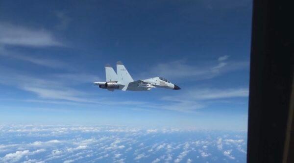 A People’s Liberation Army Navy J-11 fighter pilot performs an unsafe maneuver during an intercept of a U.S. Air Force RC-135 aircraft, which was lawfully conducting routine operations over the South China Sea in international airspace, on Dec. 21, 2022, in a still from video. (U.S. Indo-Pacific Command/Screenshot via The Epoch Times)