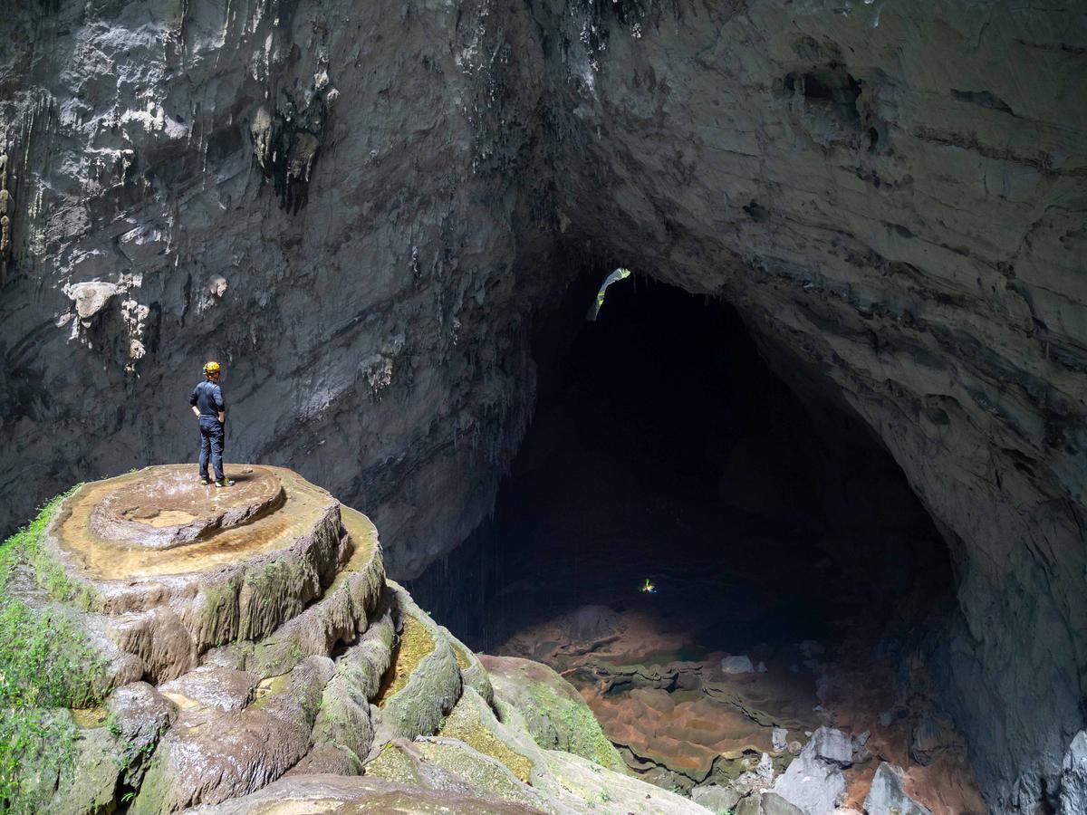 A visitor atop a stalagmite inside Son Doong cave. (hyunwoong park/Shutterstock)
