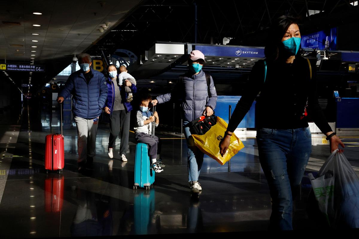 Travelers walk with their luggage at Beijing Capital International Airport, amid the COVID-19 outbreak in Beijing, China, on Dec. 27, 2022. (Tingshu Wang /Reuters)