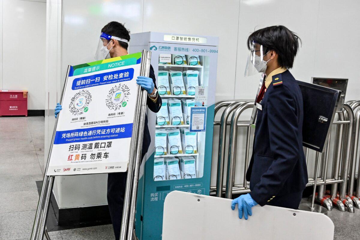 A subway staff member removed a poster for a COVID-19 health code used on entering the subway on Dec. 7, 2022, in Guangzhou in China's southern Guangdong province, following the easing of COVID-19 restrictions in the city. (CNS/AFP via Getty Images)