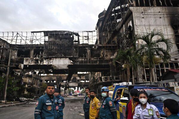 Thai rescue workers stand in front of the destroyed part of the Grand Diamond City hotel-casino after a fire in Poipet on Dec. 30, 2022. (Lillian Suwanrumpha/AFP via Getty Images)