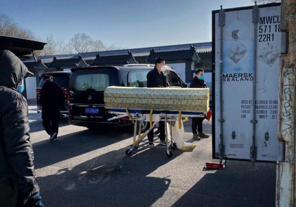 A coffin is moved from a hearse into a storage container at the Dongjiao crematorium and funeral home, one of several in the city that handles COVID-19 cases, in Beijing on Dec. 18, 2022. (Getty Images)